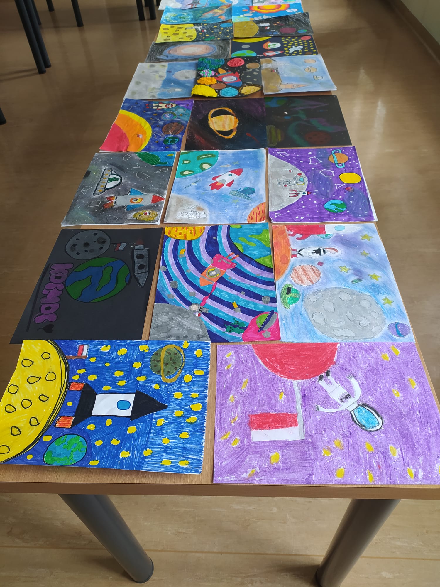 Na stoliku rozłożone prace plastyczne.