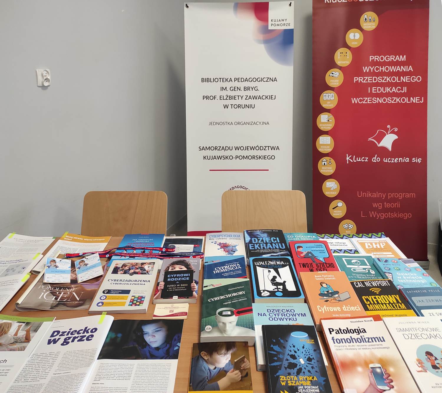 Ksiązki i czasopisma leżące na stole.