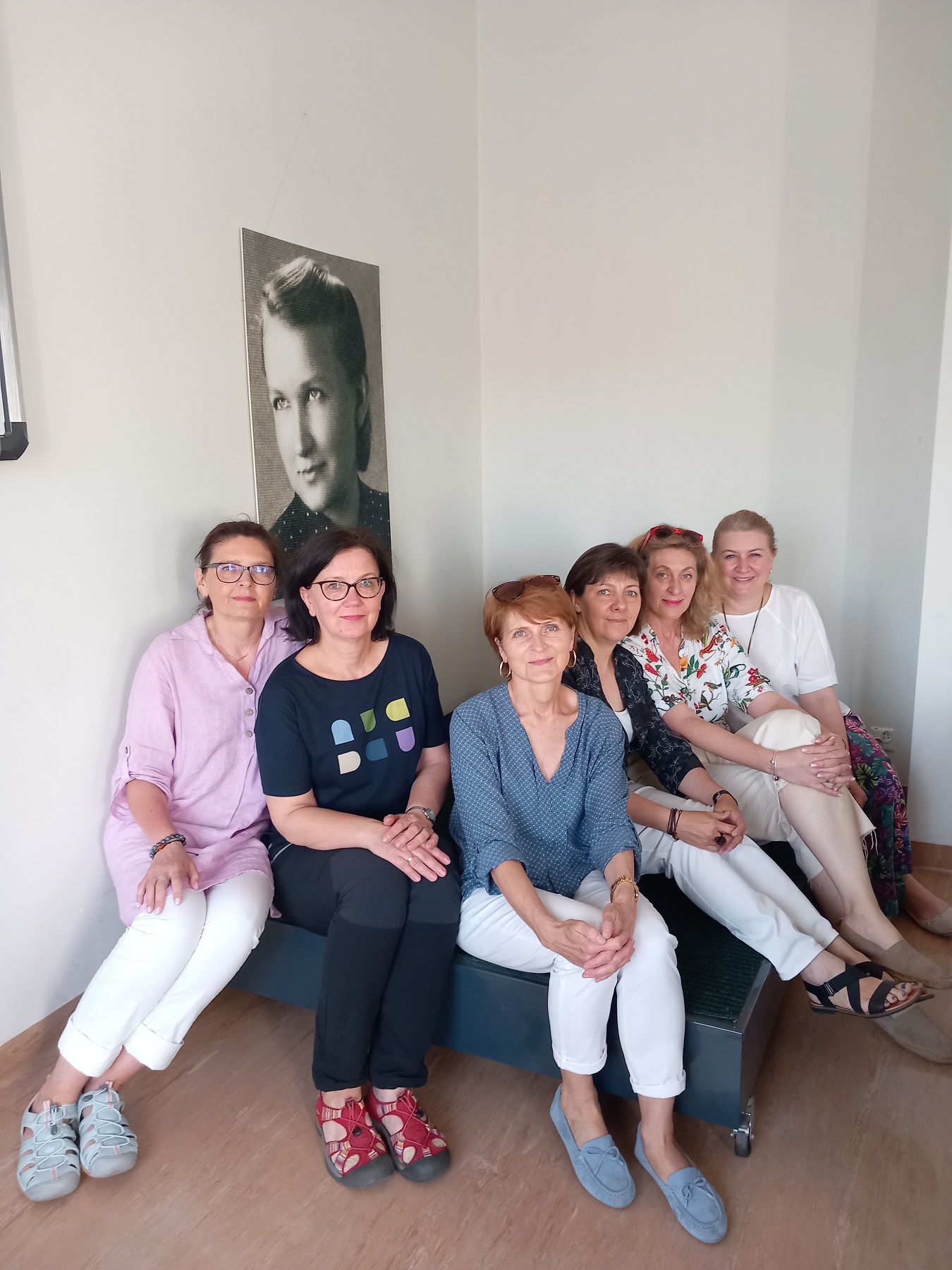 Sześć kobiet siedzących na ciemnym podeście