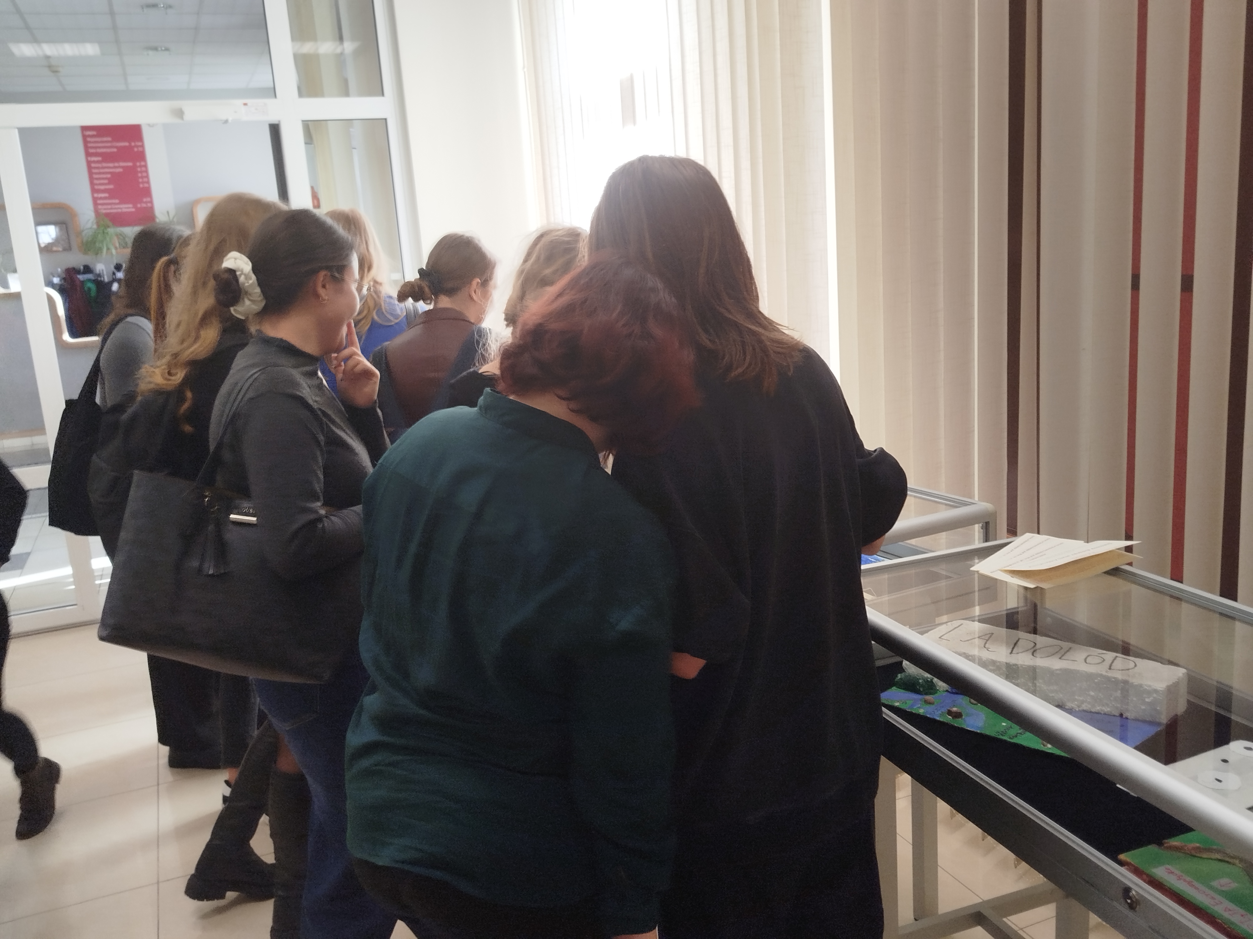 Grupa ludzi stoi w sali wystawowej Biblioteki Pedagogicznej w Toruniu.